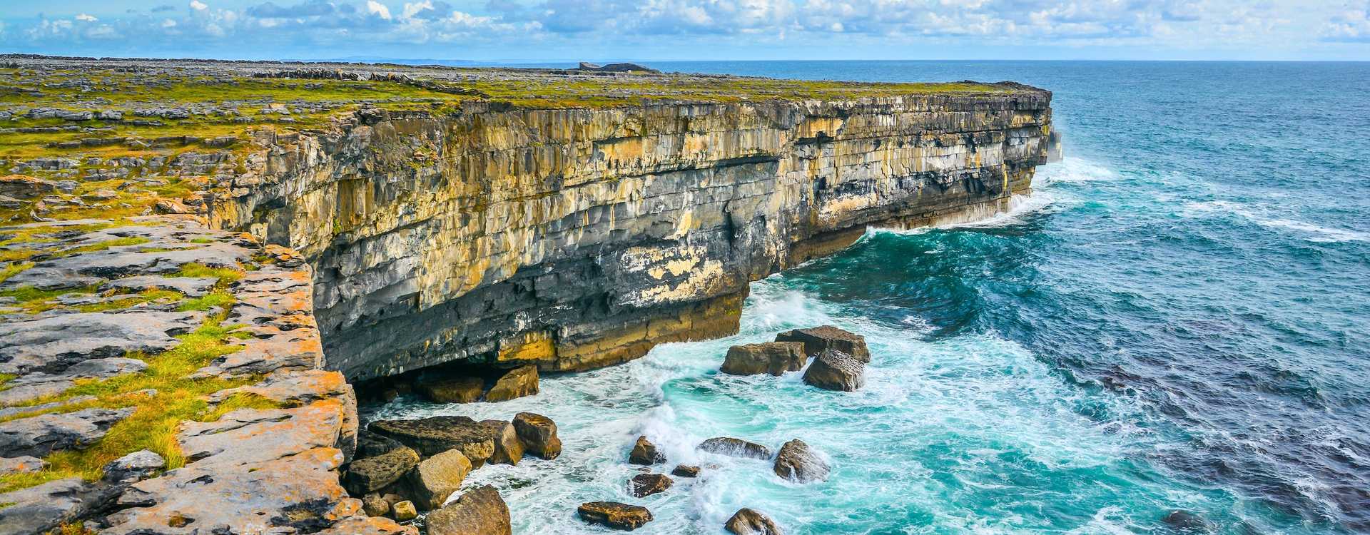 Vista panorámica de viajeros en bicicleta por los caminos costeros de piedra de Inishmore con vistas panorámicas del océano Atlántico – Guía de viaje definitiva para excursiones a las Islas Aran en 2026