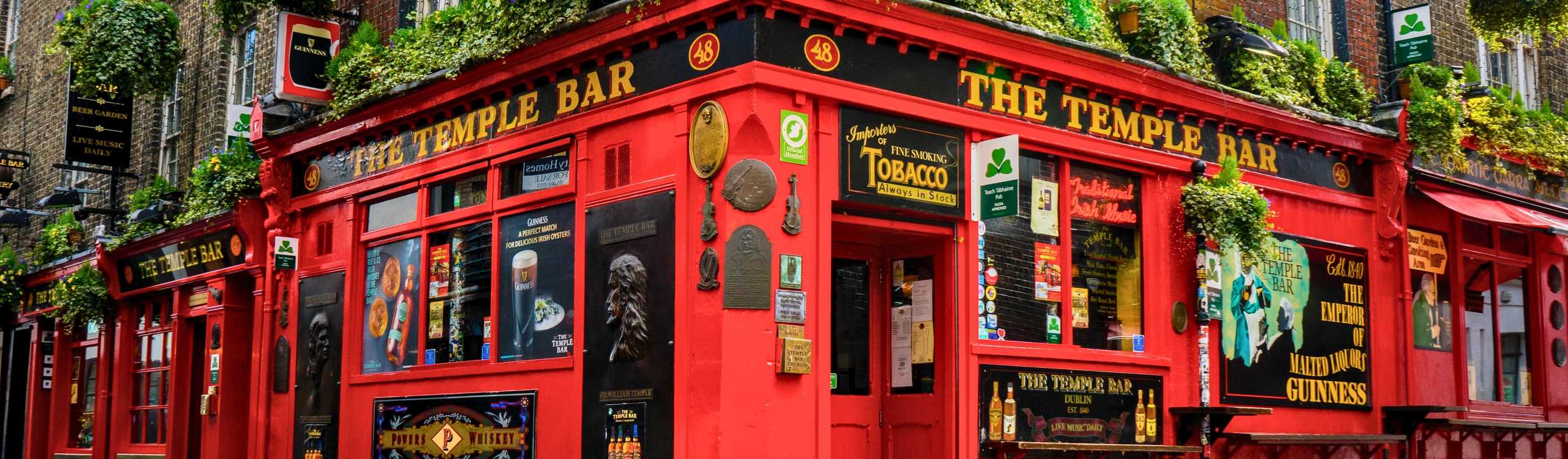 El icónico exterior rojo brillante del pub The Temple Bar en una calle adoquinada, una de las principales cosas que hacer con el Dublin City Pass en 2026